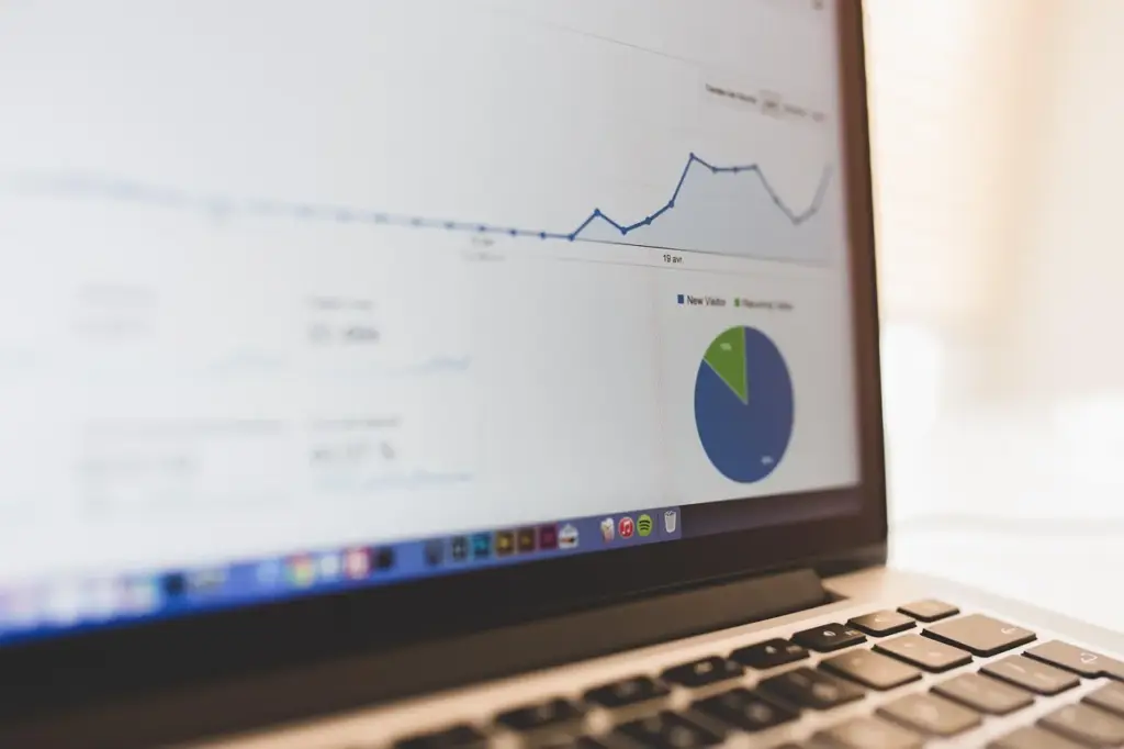 An analytics dashboard on a laptop screen showing cohort tables and retention percentages